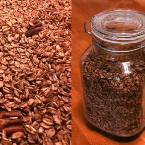 homemade cinnamon pecan granola on a baking sheet alongside the same granola stored in a glass clamp-lid jar